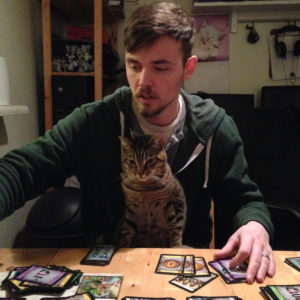 My husband playing Dominion with our cat, Kato