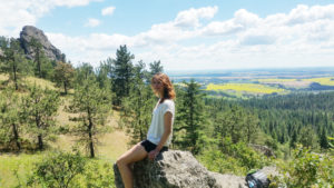 Kari sitting on a rock in front of a valley