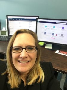 selfie of Lori Greenwood in front of computer monitors