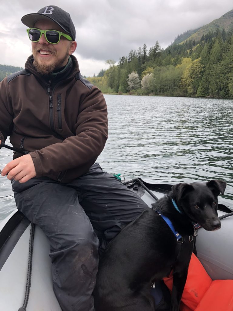 Kaleb in a raft with a black dog